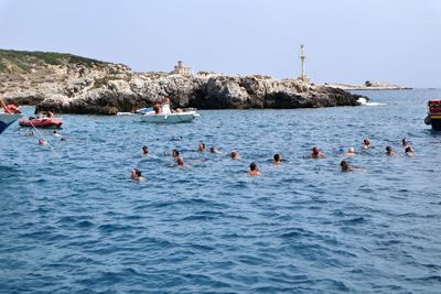 Group of people swimming in sea