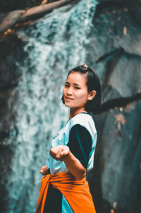 Portrait of smiling young woman standing outdoors