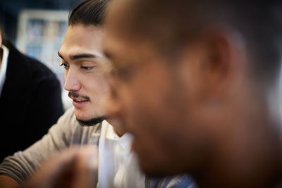 Creative businessman with male colleague during meeting in office