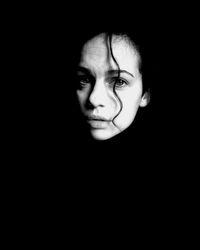 Close-up portrait of young woman in darkroom