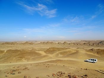 Aerial view of desert against blue sky