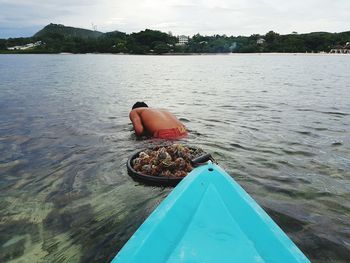 Boat moored in lake against sky