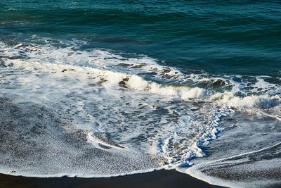 High angle view of waves rushing towards shore