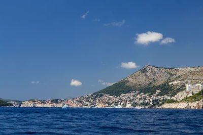 Scenic view of sea by city against sky