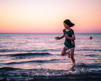 Full length of man standing at beach during sunset