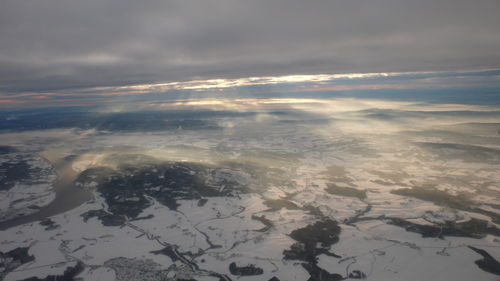 Aerial view of snowcapped landscape against sky