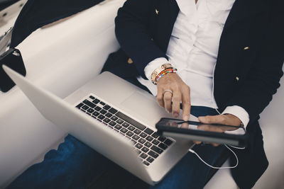 High angle midsection of senior woman using digital tablet in yacht