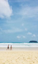 People at beach against sky