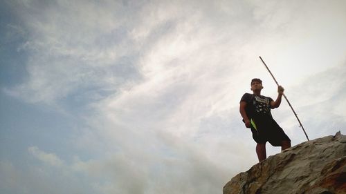 Low angle view of man standing on cliff