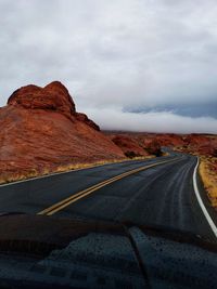 Road by mountain against sky