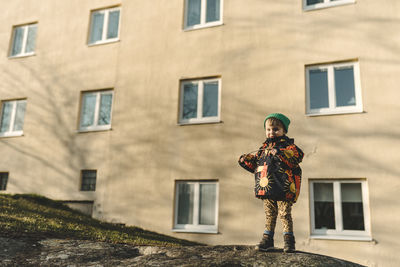 Girl standing, block of flats on background