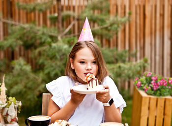 Portrait of girl holding ice cream on table