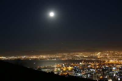 Illuminated cityscape against sky at night