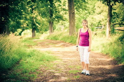 Woman with umbrella on road in forest