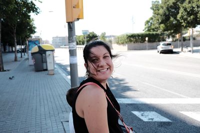 Portrait of young woman standing on road