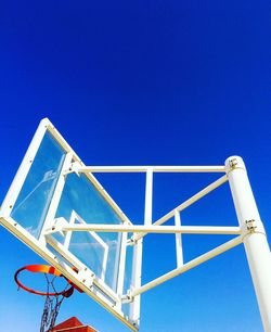 Low angle view of rollercoaster against clear blue sky