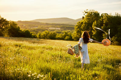 Rear view of woman standing on grassy field