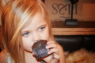 Close-up of girl holding cupcake at home