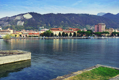 Scenic view of river by buildings against sky