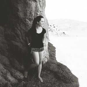 Beautiful young woman standing against sky