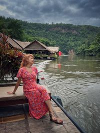 Rear view of woman sitting on boat in lake