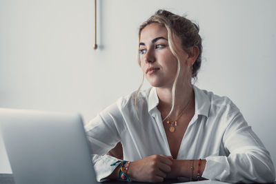 Side view of young woman using mobile phone at home