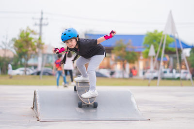 Child or kid girl playing surfskate  in skating rink 