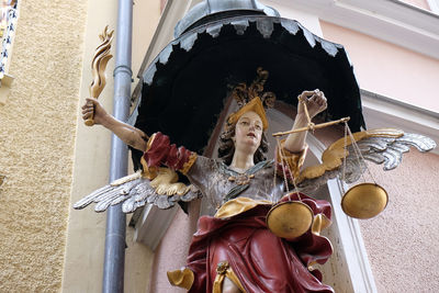 Low angle view of angel statue against building