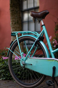 Bicycle parked on street against wall