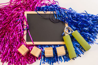 High angle view of decorations with blackboard and blocks over white background