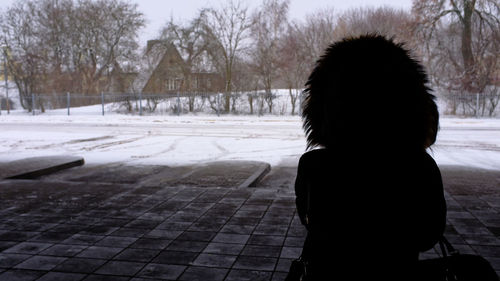 Rear view of woman standing in winter