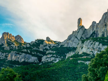 View of rocky mountain against cloudy sky