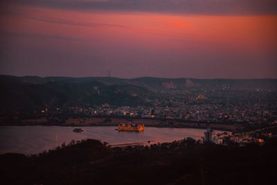 High angle view of illuminated city against sky during sunset