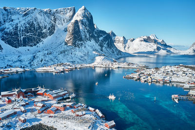 Aerial view of sea and snowcapped mountains against sky