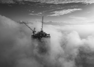 Incomplete building amidst fog against sky