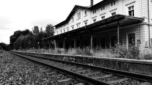 Railroad tracks by building against sky