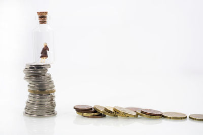 Close-up of coin in container against white background