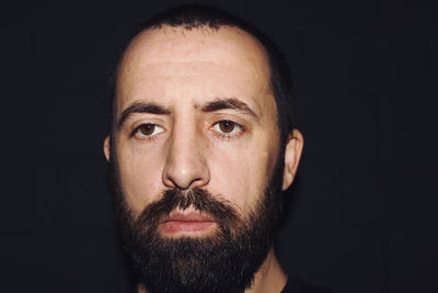 Portrait of mid adult man against black background