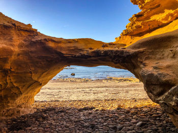 Scenic view of rocky beach against sky