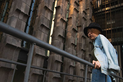 Low angle view of woman standing against building