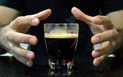 Close-up of man hands by coffee at table