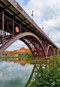 Arch bridge over river against sky