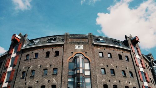 Low angle view of building against cloudy sky