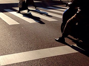 Low section of man walking on road