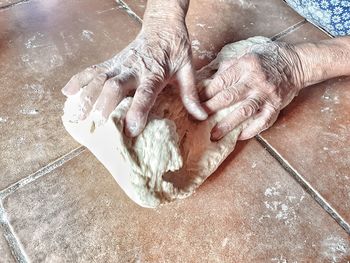 Cropped hands kneading dough