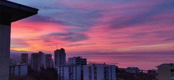 Modern buildings against sky during sunset