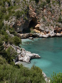 Scenic view of cliff by sea against sky