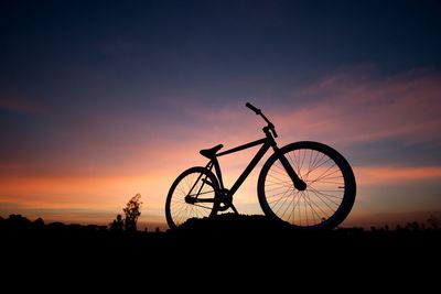 Silhouette of bicycle against sky during sunset