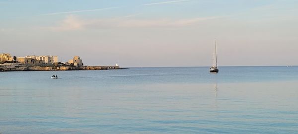 Sailboat sailing on sea against sky