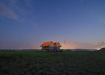 Built structure on field against sky at sunset